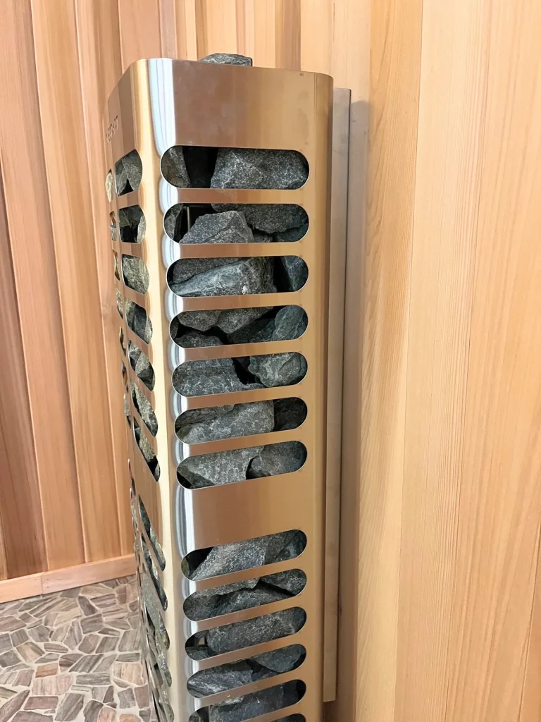 Homecraft Revive Slim sauna heater with a full-height stainless heat shield against cedar walls