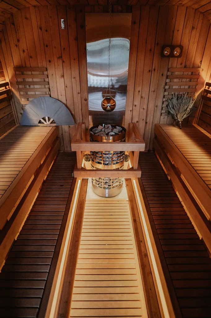Cedar sauna interior with benches down both sides and a heater at the far end