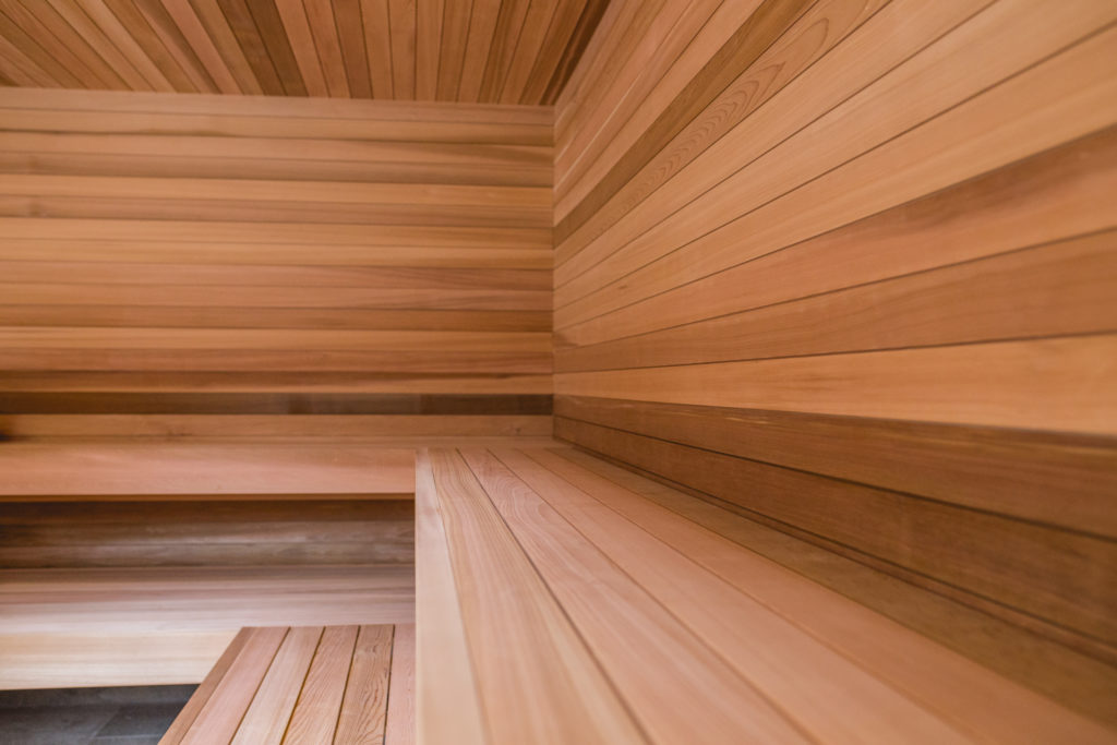 Clear western red cedar sauna corner with natural grain and colour across walls, ceiling and bench